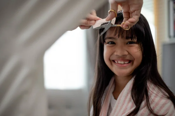 亚洲母亲在家中客厅里给女儿剪头发 同时在家中安全地呆在科维德 19号科罗纳维勒斯的家中 自我隔离和社会疏离概念 — 图库照片