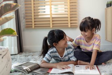 Kitap okuyan konsantre kardeşler.