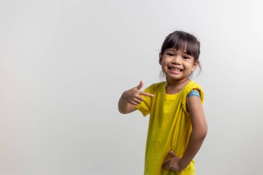 COVID 19 Vaccines for Kids concept. Studio a portrait of an adorable Asian girl after getting his first dose of vaccine. Immune, Safe, Available, Back to school.