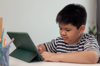Ödevi için tablet kullanan çocuk izolasyonu, internetteki dijital tablet arama bilgilerini kullanarak covid 19 tecrit, evde eğitim, sosyal mesafe, E-öğrenim çevrimiçi eğitim