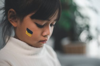 Ukrayna bayrağı taşıyan bir çocuk ağlıyor. Üzüntü, umut özlemi. Savaştan kalan çocukların gözyaşları. Sivillerin tahliyesi. Ukrayna 'ya Özgürlük