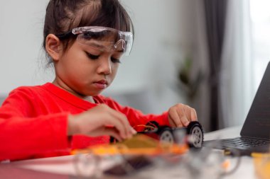 Asyalı öğrenciler evlerinde robot arabaları ve elektronik tahta kablolarını STEM, STEAM, matematik mühendisliği, bilim teknolojisi bilgisayar kodlarını çocuk konsepti için robotikte kodlayarak öğreniyorlar..