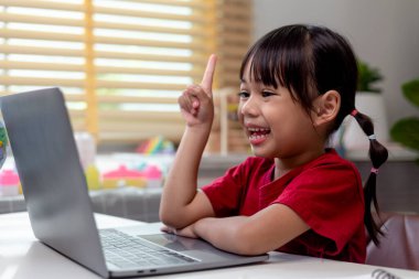 Ev karantinası sırasında bilgisayar kullanarak evde eğitim alan Asyalı bir kız. evde eğitim, çevrimiçi öğrenim, ev karantinası, çevrimiçi öğrenim, korona virüsü veya eğitim teknolojisi kavramı