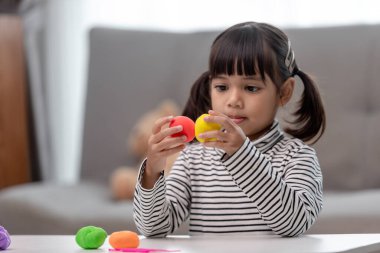 Asyalı çocuklar kil kalıplarıyla oynarlar, oyun oynayarak öğrenirler.