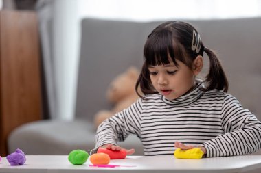 Asyalı çocuklar kil kalıplarıyla oynarlar, oyun oynayarak öğrenirler.