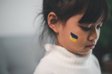 Ukrayna bayrağı taşıyan bir çocuk ağlıyor. Üzüntü, umut özlemi. Savaştan kalan çocukların gözyaşları. Sivillerin tahliyesi. Ukrayna 'ya Özgürlük