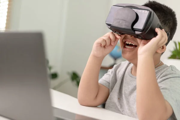 Asian Little boy with VR glasses studying sciences at home,curious student wears a virtual reality headset to study science home online study futuristic lifestyle learning