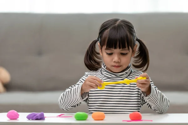 Asian kids play with clay molding shapes, learning through play