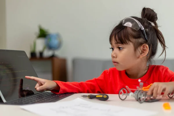 Asia students learn at home in coding robot cars and electronic board cables in STEM, STEAM, mathematics engineering science technology computer code in robotics for kids concept.