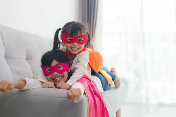 happy and confident young kids playing and dressing up as super hero together