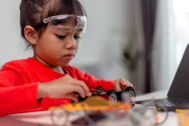Asyalı öğrenciler evlerinde robot arabaları ve elektronik tahta kablolarını STEM, STEAM, matematik mühendisliği, bilim teknolojisi bilgisayar kodlarını çocuk konsepti için robotikte kodlayarak öğreniyorlar..