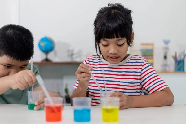 Asian Children enthusiastically watch chemistry experiments.