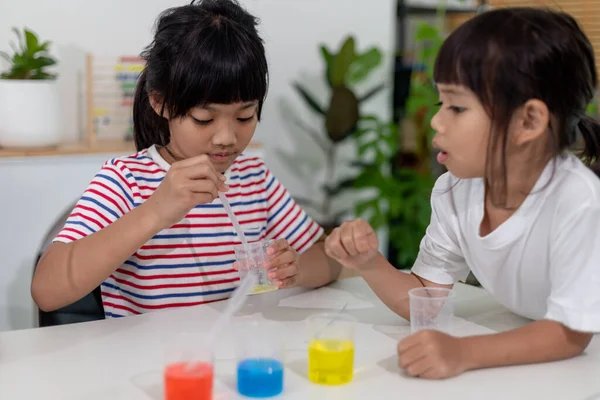 Asian Children enthusiastically watch chemistry experiments.