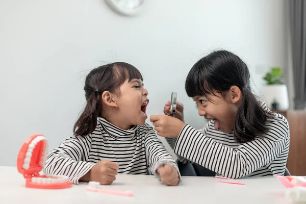 Cute Asian child playing with doctor dentist toy set, child shows how to clean and care for teeth. Dentistry and medicine,