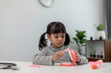 Küçük bir çocuk yapay çenelerle oynar. Çocuk dişçiliği.