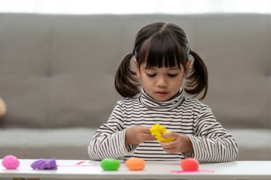 Asyalı çocuklar kil kalıplarıyla oynarlar, oyun oynayarak öğrenirler.