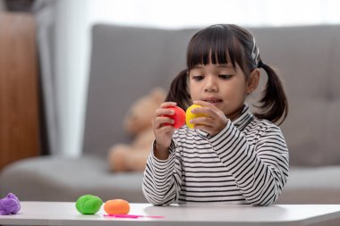 Asyalı çocuklar kil kalıplarıyla oynarlar, oyun oynayarak öğrenirler.