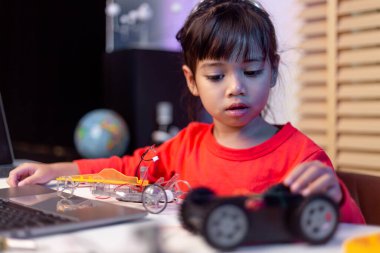 Asyalı öğrenciler evlerinde robot arabaları ve elektronik tahta kablolarını STEM, STEAM, matematik mühendisliği, bilim teknolojisi bilgisayar kodlarını çocuk konsepti için robotikte kodlayarak öğreniyorlar..