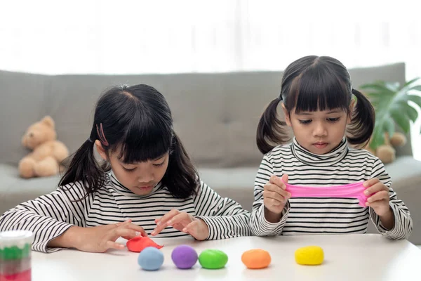 Asian kids play with clay molding shapes, learning through play