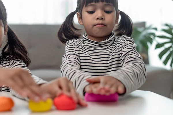 Asian kids play with clay molding shapes, learning through play