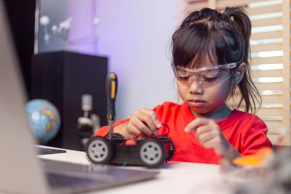 Asia students learn at home in coding robot cars and electronic board cables in STEM, STEAM, mathematics engineering science technology computer code in robotics for kids concept.