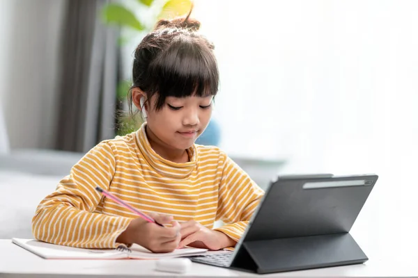 Asian girl students in online learning classes study online with Tablet at home.