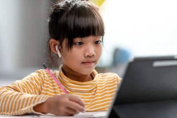 Asian girl students in online learning classes study online with Tablet at home.