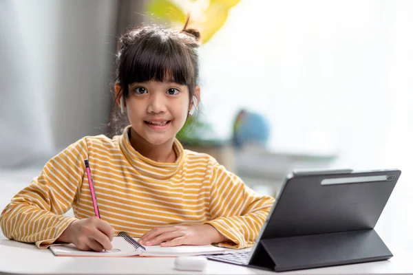 Kid self isolation using tablet for his homework,Child doing using digital tablet searching information on internet during covid 19 lock down,Home schooling,Social Distance,E-learning online education