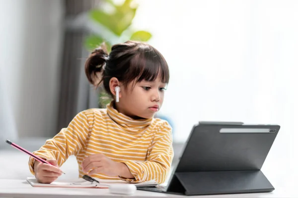 Asian girl students in online learning classes study online with Tablet at home.