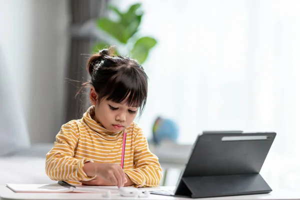 Asian girl students in online learning classes study online with Tablet at home.