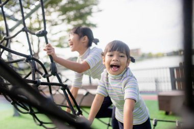 Little school kids climbing in the school playground.