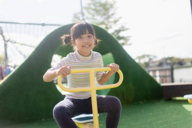 Kids playing at the see-saw in the playground