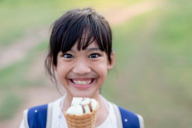 Dondurma parkta bir yürüyüş ile sevimli bir kız portresi. Çocuk açık havada