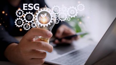 Sanal ekranda ESG ikonlu bir ampulü tutan iş kadını, ESG Çevre, Sosyal ve Kurumsal Yönetim kavramı.
