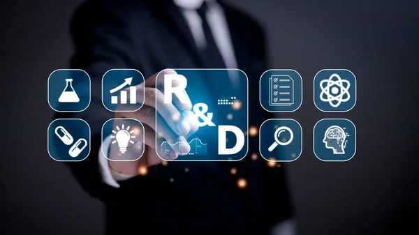 Hand of businessman holding a pen pointing to R and D icon for Research and Development on laptop screen. Manage costs more efficiently. R and D innovation concept.