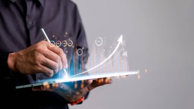 İnsanlar tablet kullanıyor ve sanal ekranda görünen bir iş grafiği ile parmaklarını ekranda kullanıyor. Yeni başlangıç fikirleri ve iş büyümesi kavramı..
