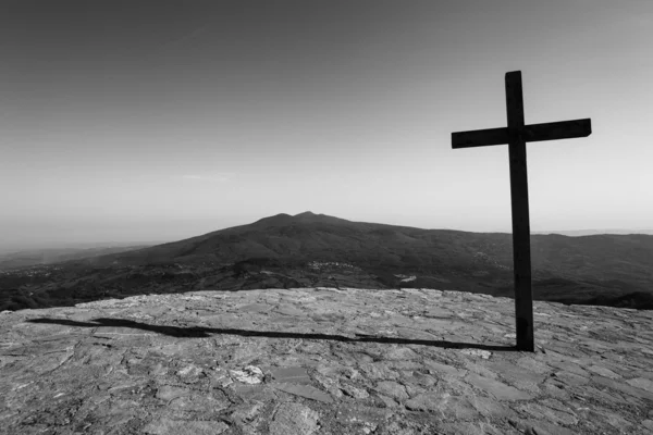 Black cross with mountain in background