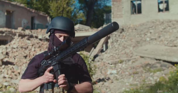 Солдат на тлі зруйнованої будівлі придумав магазин з патронами для гвинтівки — стокове відео