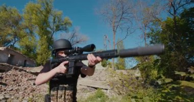 Tüfekli bir asker, yıkılmış evin yakınındaki keşif yerine gidiyor.