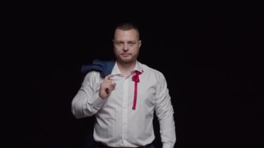 Beyaz gömlekli ve düğmesiz kırmızı kravatlı seksi bir adam küstahça ileriye bakıyor.