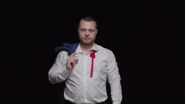 Beyaz gömlekli, omuzunda ceket olan sakallı bir adam parmağını öne uzatıyor.