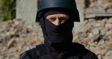 Kasklı bir asker etrafa bakıyor. Yakın plan..