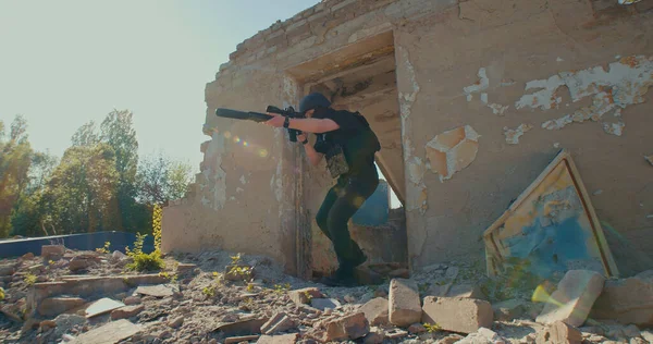 ライフルを持った兵士が廃墟から出てきて銃弾を狙う — ストック写真