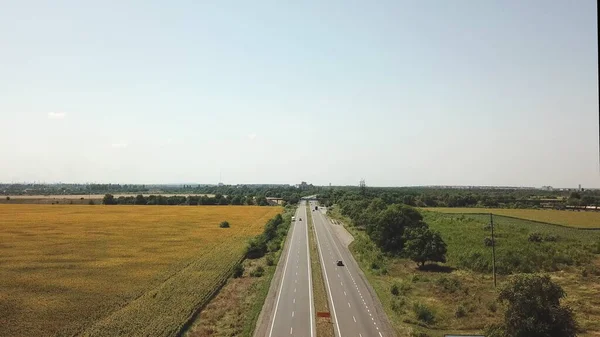 Dağlık bir bölgede hareket halindeki bir araçla yola çıkan bir İHA 'nın yardımıyla havadan görüntüyü alın. Ukrayna 'nın güneyinden yeşil tarlalar ve tepeler.