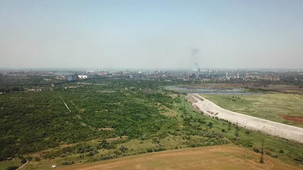 Ekolojiyi borulardan gelen dumanla kirleten bir bitkinin yakınındaki buğday tarlasında yüksek uçuş