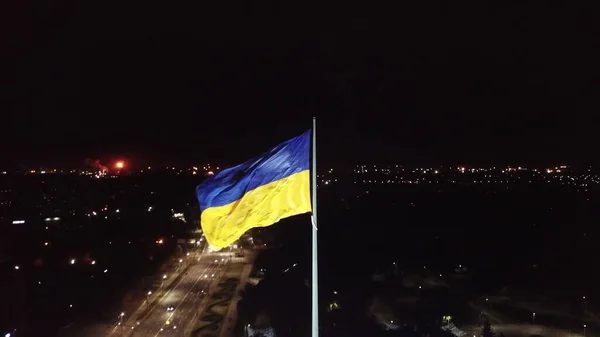 Hava görüntüsü. Ukrayna bayrağı geceleyin rüzgârda dalgalanır. İHA 'nın yüksek açılı görüntüsü taranıyor. Kryvyi Rih. Dnipro bölgesi.