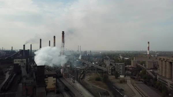 Hava atmosferi ve metalürji fabrikasından kaynaklanan nehir suyu kirliliği olan sanayileşmiş şehir üzerinde hava manzarası. Çelik fabrikası ve kokain fabrikasından kirli duman ve duman. Ekolojik.