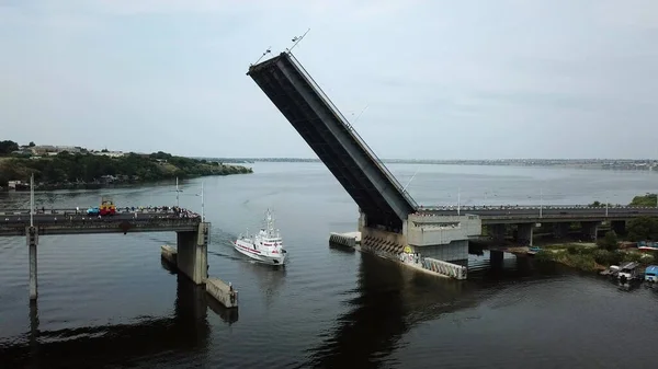 A medical ship sails under a raised bridge.Drone aerial high angle view panning