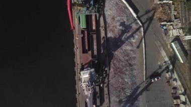 Limanın sanayi bölgesinde yük vinçlerinden dökme demir boşaltılıyor. - Lojistik sektörü, nakliye işi konsepti. İHA yüksek açı görüntüsü taraması