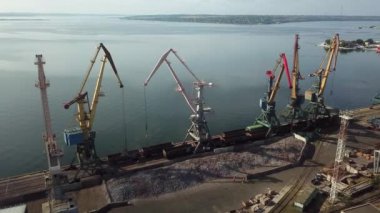 Limanın sanayi bölgesinde metal yük vinçleri için terminaller. Vagonlardan dökme demir. Lojistik endüstrisi, nakliye işi konsepti. İHA yüksek açı görüntüsü taraması.